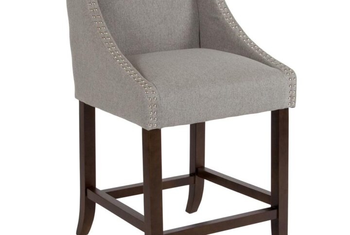 This classically sophisticated light gray fabric upholstered counter stool with decorative nail trimming lends a touch of old world elegance and comfort. The solid wood frame and legs are streamlined with a touch of whimsy mimicking the curved design details of the arms. The deep seat is an invitation to lounge