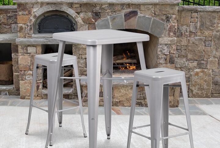 The trendy square indoor-outdoor metal dining table with two square backless barstools will give your dining room or bar decor a cool retro-vintage feel. The table top measures 23.75 inches square and has a 2-inch lip with rounded corners. Cross braces add increased stability while still allowing ample leg room. Galvanized steel construction and a smooth