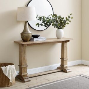 this stately console table adds style wherever it goes. The rectangular tabletop is enhanced by large pedestal columns with decorative trim on the trestle base. Ready to be used as a sofa table or a foyer drop-zone