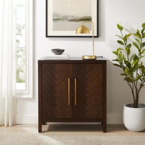 this accent cabinet features two adjustable shelves behind double cabinet doors. The doors showcase a bold herringbone pattern and oversized hardware