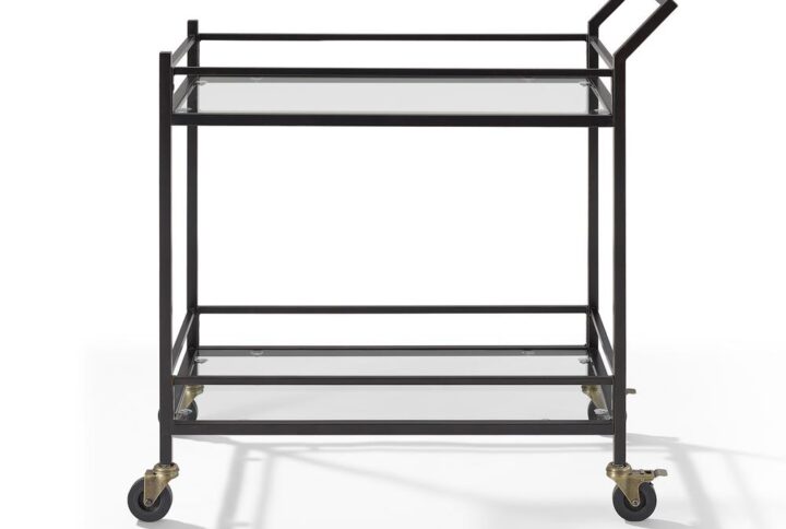 The modern style of the Aimee bar cart makes it an eye-catching addition to any home. A sturdy steel frame and tempered glass shelves create a simple silhouette that works with a variety of décor aesthetics. Fitted with four castors
