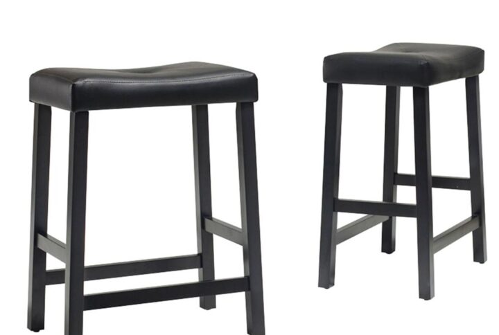 Simplicity and comfort are hallmarks of the Saddle Seat 2pc Counter Stool Set. The curved seat is upholstered in a durable yet stylish faux leather