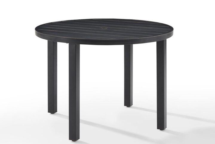 Gather around the Kaplan Round Dining Table for a cozy meal al fresco. The round table features a slatted design that elevates the sturdy steel construction. A standard umbrella hole allows you to add some shade on a hot summer day. Simple and stunning