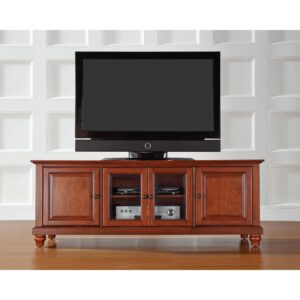 Enhance your living space with the impeccably-crafted Cambridge 60” Low Profile TV Stand. This beautiful TV stand accommodates most 65" flat-panel TVs and blends with a variety of home decor. Two cabinets have raised panel doors for concealed storage. The center cabinet has beveled glass doors that protect valued electronic components while allowing for complete use of remote controls. Adjustable shelving offers an abundance of versatility