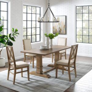 offering seating for four diners. Each chair features upholstered backs and seats with a classic wooden X design on the back. Balancing the table’s substantial trestle base is a spacious tabletop