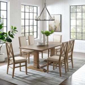 offering seating for up to six diners. Each chair features upholstered backs and seats with a classic wooden X design on the back. Balancing the table’s substantial trestle base is a spacious tabletop