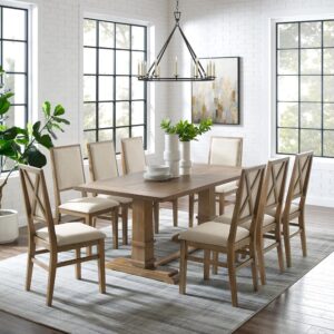 offering seating for up to eight diners. Each chair features upholstered backs and seats with a classic wooden X design on the back. Balancing the table’s substantial trestle base is a spacious tabletop