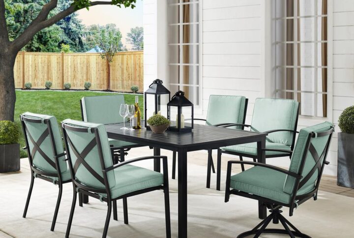 Gather for an elegant outdoor meal with the Kaplan 7pc Outdoor Dining Set. Featuring two 360-degree swivel chairs and four stationary dining chairs that surround a classic rectangle dining table
