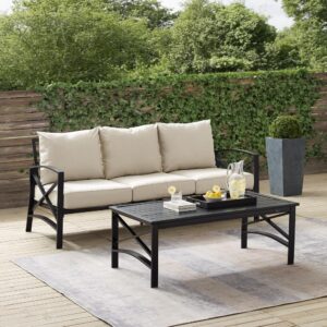 this set features sturdy steel construction with a transitional x-back design. The sofa's comfortable seat and back cushions are covered in solution-dyed polyester