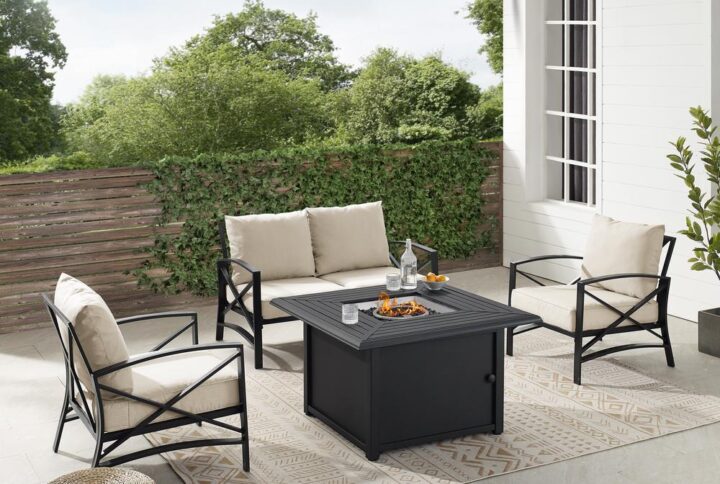 Gather for an evening around the fire with the Kaplan 4pc Outdoor Conversation Set. A loveseat and two arm chairs surround the propane-powered fire table
