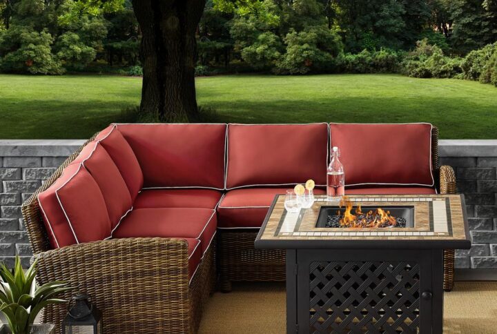 Cozy up in the luxury of the Bradenton 4pc Sectional Set. Sectional seating for up to five hugs the powder-coated steel fire table offering deep seat cushions on all-weather resin wicker. The sectional cushions are covered in a solution-dyed polyester for durability and comfort. The fire table's tiled stone top and lattice paneled base offer a unique design that elevates any outdoor space. The gas controls and a rack for a propane tank are located inside the table's base