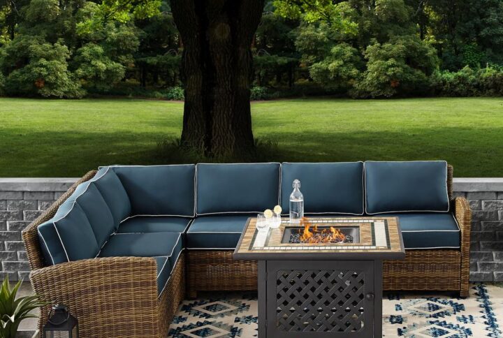Cozy up in the luxury of the Bradenton 5pc Sectional Set. Sectional seating for up to six hugs the powder-coated steel fire table offering deep seat cushions on all-weather resin wicker. The sectional cushions are covered in a solution-dyed polyester for durability and comfort. The fire table's tiled stone top and lattice paneled base offer a unique design that elevates any outdoor space. The gas controls and a rack for a propane tank are located inside the table's base