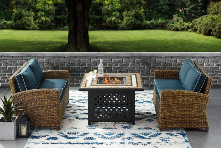 Relax by the warmth of the fire with the Bradenton 3pc Conversation Set. The loveseat and armchair are made from all-weather resin wicker with seat cushions covered in solution-dyed polyester. The outdoor seating surrounds a fire table constructed from sturdy powder-coated steel. The fire table's tiled top and lattice paneled base offer a unique design that will elevate your outdoor space. The gas controls and a rack for a propane tank are located inside the table's base