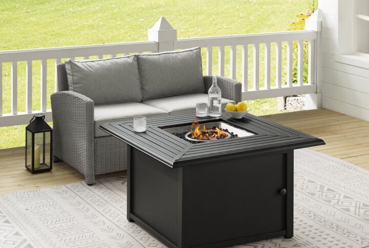 Spend warm summer days and cool summer nights with the Bradenton 3Pc Conversation Set. The loveseats are made from all-weather resin wicker with cushions covered in solution-dyed polyester. The outdoor seating surrounds a fire table constructed from sturdy powder-coated steel. The fire table's slatted top and solid paneled base offer a simple design that blends with a variety of outdoor spaces. The gas controls and a rack for a propane tank are located inside the table's base