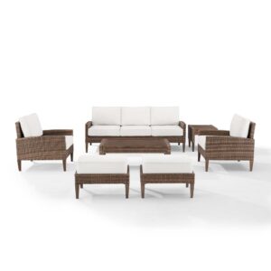 this set features all-weather resin wicker and hand-painted steel with a natural wood look. Beautiful quick-drying olefin fabric adds durability to the cushioned seating and ottomans