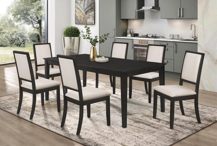 Get a tuxedo-inspired modern dining table set for your home. This seven-piece dining set offers a stark contrast with a black and cream color palette. Made from Asian hardwood and ash veneer