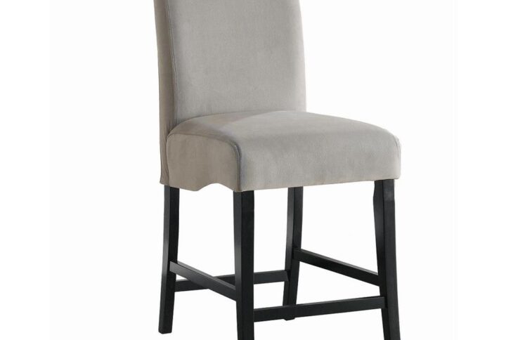 Pull up this counter height chair from the Stanton collection to your favorite kitchen counter. It has a flared back and padded seating designed for comfort and enjoyment over a home-cooked meal or hand-crafted old fashioned. Upholstery is wrapped in grey fabric and legs are finished in black. Styled to suit a contemporary kitchen or home bar. Durable enough for hours of discussing your next merger or coaching decisions from your kid's little league game.