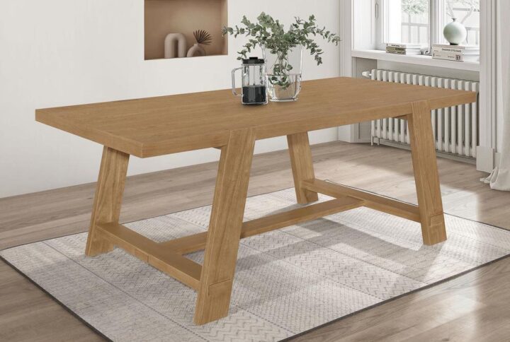 Elevate your dining room with the captivating blend of modern farmhouse style in this stunning dining table. The brown wire-brushed finish highlights the natural beauty of the wood