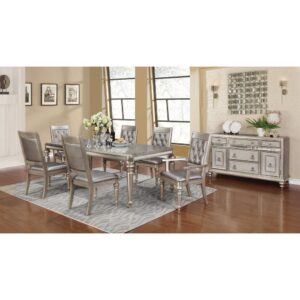 Add glamor to family gatherings around the dinner table with this stunning 5-piece set. Rectangular table is fashioned from Asian hardwood that's durable and reliable. It also has an extension leaf with all wood glides to accommodate the ultimate dinner party. Four sumptuous side chairs come upholstered in metallic leatherette with button-tufted backs. Entire set is finished in a brilliant platinum metallic with a magnificent hand-applied glaze.