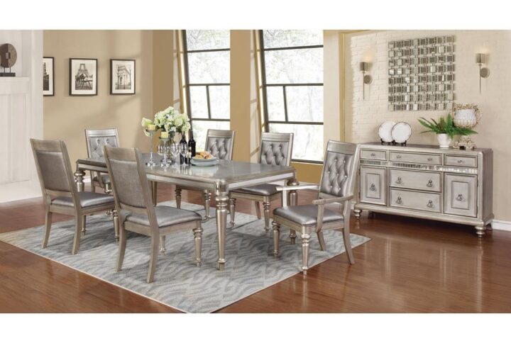 Add glamor to family gatherings around the dinner table with this stunning 5-piece set. Rectangular table is fashioned from Asian hardwood that's durable and reliable. It also has an extension leaf with all wood glides to accommodate the ultimate dinner party. Four sumptuous side chairs come upholstered in metallic leatherette with button-tufted backs. Entire set is finished in a brilliant platinum metallic with a magnificent hand-applied glaze.