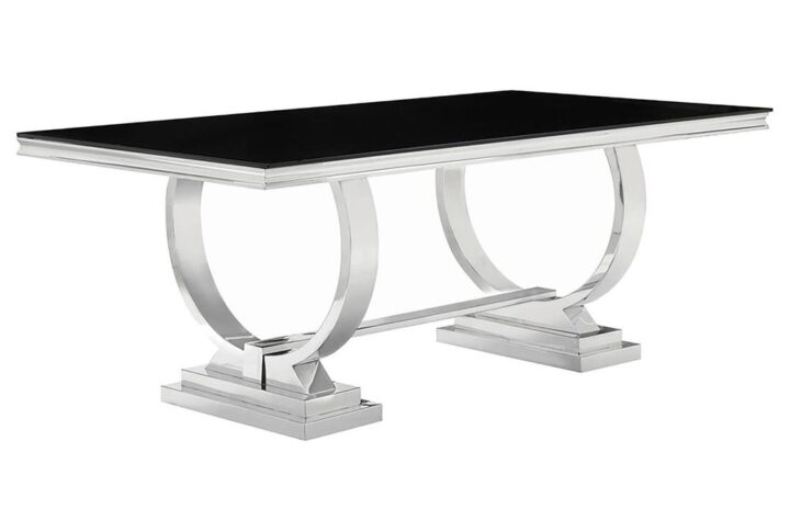 This dining table has a unique design that's an ideal complement to a contemporary style home. Large rectangular top is finished in black with silver edges. Silver legs are fashioned in a ring-like circular design atop two silver tiered bases. With a set of well-made chairs