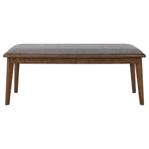 this everyday dining bench delivers a fresh new vibe that blends perfectly in modern or more traditional design schemes. Warm walnut finish wood composition shows off a minimalist profile with mid-century flat tapered legs and a lip around its padded seat. Beautifully neutral fabric upholstery adds a homey touch. Choose this bench as a delightful alternative to conventional seating.
