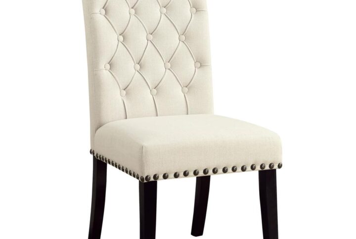 Airy elegance adds a charming touch in a semi-casual space. This dining chair celebrates style with a lovely beige fabric upholstery. Linear design offers an armless profile with tapered legs. A tufted seat back and nailhead trim build its personality with a touch of character. Contrast created by deep finished legs shapes the décor allure of this exceptional dining chair.