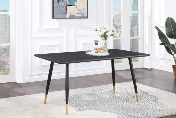 Infuse your dining area with a modern touch using this exquisite mid-century dining table. The striking combination of black and gold accents adds a luxurious flair. Crafted from oak veneer with an MDF core