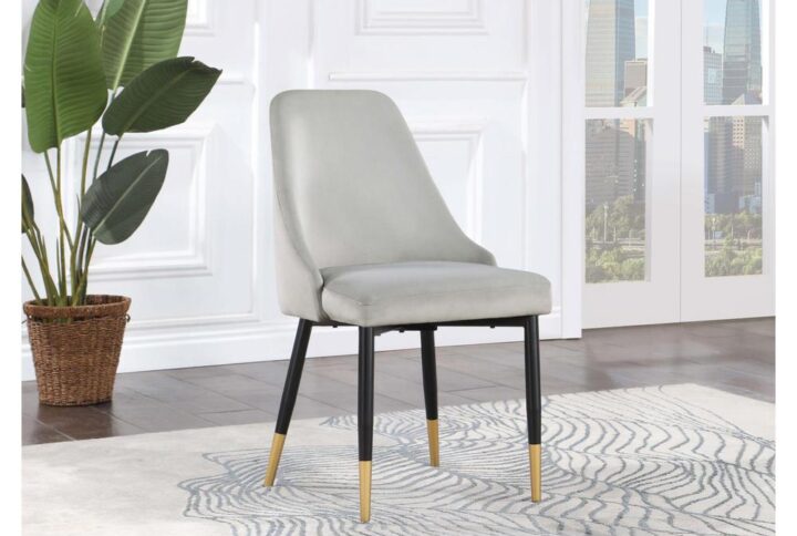 Add a touch of glamour to your dining space with this dining side chair. Featuring splayed gold-capped legs