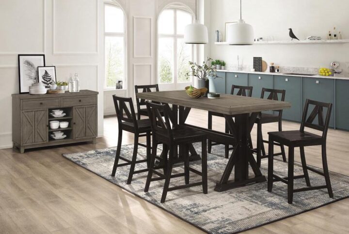 Entertain in style with a crisp modern look with shades of industrial style. Five pieces make up a tasteful counter height dining set adding a sense of sophistication to a casual space. A rectangular counter height table made of barn gray finish wood tops a bold black sand finish wood trestle-like base with geometric silhouetting. Matching black sand wood counter height stools offer an extra deep seat