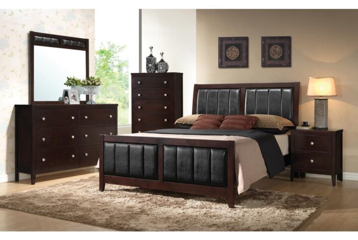 The Carlton collection is highlighted by this impressive 4-piece bedroom set that features black leatherette padding throughout. The high headboard and low footboard of the bed have vertical leatherette padded paneling for sumptuous style and majesty. The nightstand has two deep drawers and a table top for a matching table lamp. The dresser includes six deep drawers and a spacious top for the nearly-square mirror