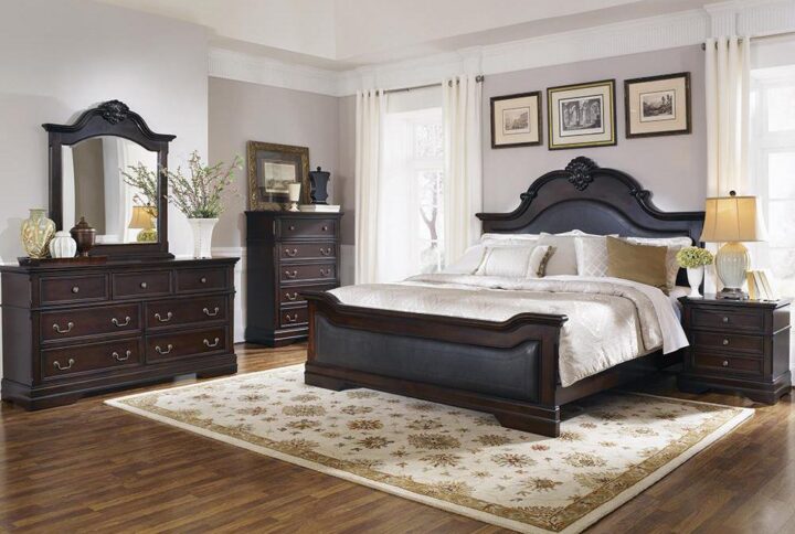 This stately 5-piece bedroom set from the Cambridge collection has a traditional design and construction that's the grand centerpiece of any master bedroom. The bed is constructed with an arched headboard with crown molding and carved details and upholstered in sumptuously padded leatherette. The dresser