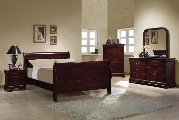 Warm color and simple curves from this wood queen bed create an air of elegance. Matching geometric beveling along the headboard and footboard create a well-balanced sense of refinement. A slightly higher headboard plays into classic louis Philippe style. Clean and simple lines balance out the texture for the exposed wood grain and lend toward modern design. In a red brown finish