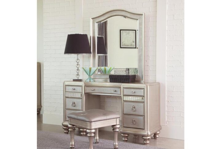 Feel like you’re sitting on a throne when you take seat at this exceptional vanity set. The exceptional metallic platinum finish boasts plenty of character along with the textured drawer panels with mirrored accents. The curved tabletop mimics the gorgeous camel top mirror. Seven drawers are available for storing makeup and other small items.  Coming with an upholstered leatherette vanity stool