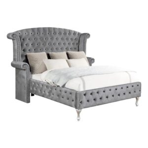 regal headboard features rolled wingback styling complete with armrests that's both chic and comfortable. Both the headboard and footboard come with button tufted styling for added flair. The bed is upholstered in grey with metallic accents and nailhead trim. This bed is a truly magnificent addition to the bedroom.
