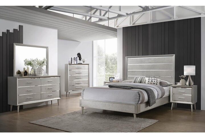 Update your bedroom to a glamourous modern space with a bedroom set from the Ramon collection. Mid-century modern lines get an unexpected dose of luxe style with metallic and mirrored finishes in this distinctive modern glam bedroom set. Beveled mirrored surfaces peek from behind textured metallic silver panels for a Hollywood look. Felt-lined top drawers protect your jewelry and keepsakes. Choose from a full range of bed sizes and furniture pairings to create the perfect modern glam bedroom.