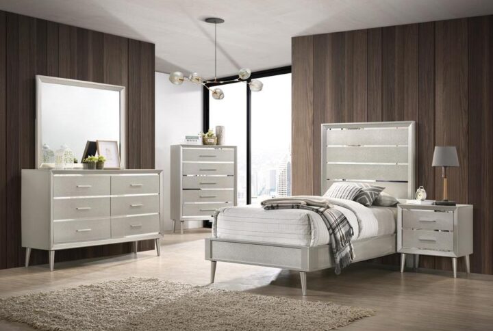 Update your bedroom to a glamourous modern space with a bedroom set from the Ramon collection. Mid-century modern lines get an unexpected dose of luxe style with metallic and mirrored finishes in this distinctive modern glam bedroom set. Beveled mirrored surfaces peek from behind textured metallic silver panels for a Hollywood look. Felt-lined top drawers protect your jewelry and keepsakes. Choose from a full range of bed sizes and furniture pairings to create the perfect modern glam bedroom.