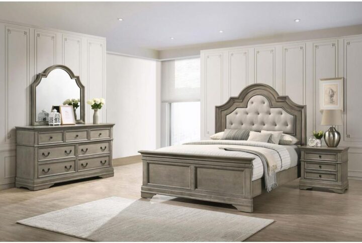 Create the ultimate bedroom retreat with this four-piece bedroom set in a gray undertone wheat finish. Spacious drawers adorned with dark bronze hardware offer a striking contrast and accent as the headboard and framed mirror offer graceful lines with a scalloped bonnet arch. Most notably