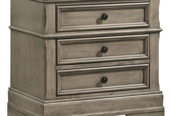 Traditional crown molding details and wood trim offer striking dimension to this transitional three-drawer nightstand. A charming wheat finish with gray undertones lends a rustic-inspired flair and country vibe that works with modern farmhouse style bedrooms and European cottage retreats. A felt-lined top drawer invites you to keep delicate accessories tucked securely away as dark bronze drawer pulls offer a pop of contrast to the wood finish. Hidden