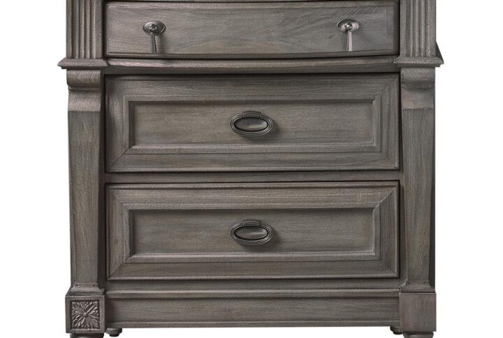 Upgrade the elegance of your home decor with the updated transitional design of this three-drawer nightstand. It features a gorgeous classic French neoclassical design reimagined for today. The stunning sand blasted wood finish with just the right amount of French grey is a pure delight. The drawers are crafted with antique silver metal finished pendant and ring pull hardware