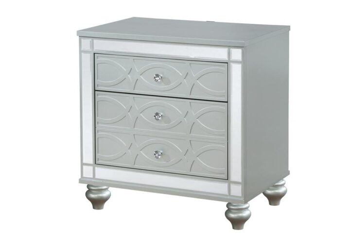 Bring modern glam to a classic design with this transitional two-drawer nightstand. It features a glitzy design that draws the eye in any modern home. It's crafted with a vibrant silver metallic finish with fret work detail on the front panels and drawer fronts. The drawers are adorned with crystal-like pulls and the top one is lined with black felt. Dual USB ports and delicate bun feet complete the design of this exquisite accent piece.