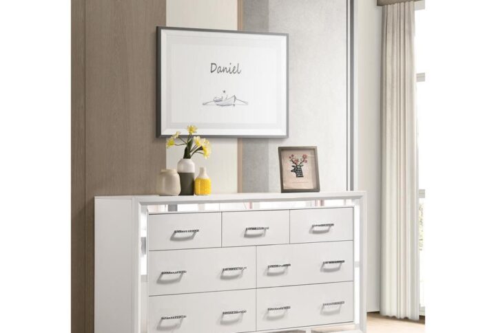 An on-trend seven-drawer dresser puts a twist on the typical two-tone design. It features a modern glam design that upgrades the fab factor of any bedroom. The dresser is crafted with a white and silver finish that will brighten up any contemporary home. The drawers are adorned with lustrous chrome bling pull handles