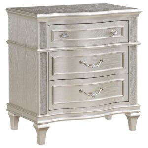 Keep all your bedroom essentials and wardrobe items neatly organized with this glam three-drawer nightstand. A contoured frame design features sparkling side panels flanking the three spacious drawers for a luxurious touch. A silver oak finished wood frame is accented further by modern glam metal knobs and bail handles that help slide each drawer with ease. A soft grey felt-lined top drawer invites you to store more delicate items. A hidden USB outlet creates a convenient charging area for handheld devices.