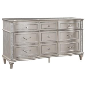 A silver oak finish creates an elegant touch to this glam nine-drawer dresser. Hexagon-shaped knobs and drop bail handles appointed with pearl accents adorn each of the nine spacious drawers for a luxurious look and feel. Keep delicate essentials organized within the grey felt-lined top drawers and garments in the deep bottom drawers. Across the dresser front is a curved facade that sweeps through the drawer fronts and ends at two sparkling column panels. Charming wood molding details along the top and bottom