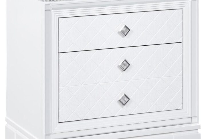Clean lines and luxe details shine through in this two-drawer nightstand from the Eleanor bedroom set. Sparkling accents like a reflective mirror trim outlining the set of drawers and square knobs encrusted with diamond-like accents create a regal display against a bed. This glam nightstand opens itself up to whatever color palette you prefer and offers hidden extras like USB charging ports and a felt-lined top drawer for delicate accessories and jewelry. Lending to the understated white finish is textured drawer fronts embossed in a wild crocodile and diamond pattern. Along the top just below the tabletop surface is a slim crystal-like molding that completes the piece and mirrors the hardware.