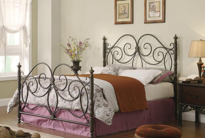 The London metal bed is a traditional-style headboard/footboard. Both feature a beautiful scroll design that is visually striking. The bed posts are capped with turned finials that add distinction. Headboard and footboard are wrapped in warm dark bronze. Decorative and classic