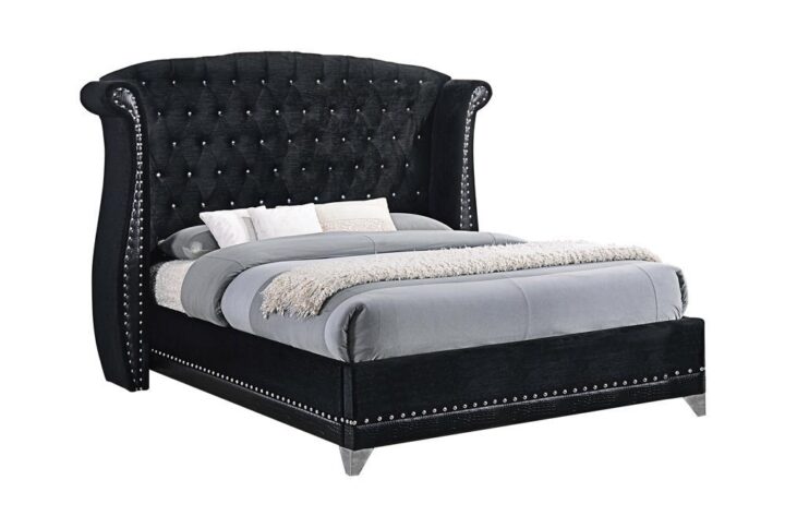 This magnificent bed is designed for sleeping in comfort and style. Headboard is constructed with button tufting and a wingback design that warmly embraces you. Bed is wrapped in sumptuous black with contrasting nailhead trim throughout. It's a bed fit for a regal setting. Note: a box spring is required for this majestic bed.