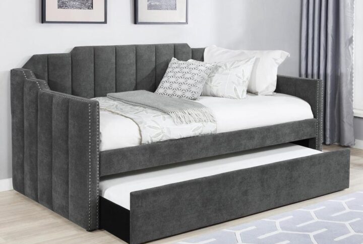 Welcome guests to stay for the night with this contemporary twin daybed and trundle set. Wrapped entirely in a charcoal gray velvet fabric with an Art Deco-inspired channel tufted design and stepped edges