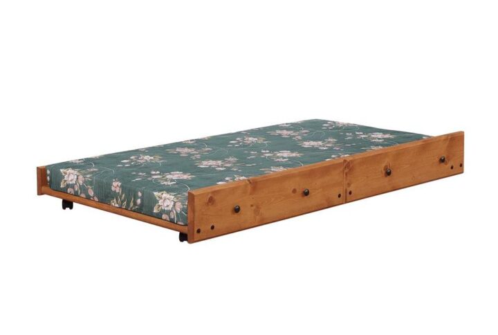 The Wrangle collection presents this rustic youth trundle bed that's a showpiece of any guest or youth bedroom. Climb up to the top sleeping space on the handy ladder at the ends of the bed. Top bunk features side slats to keep the sleeper safe and secure. Finished in amber wash for a bucolic appearance that looks great with any bedroom decor. Includes bunkie mattress for convenience.