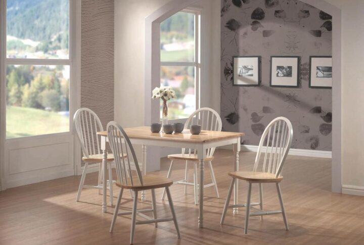 A tempting and familiar design motif shows itself off in a stylish way as it updates your casual space with farmhouse charm. This five-piece dining set features wood construction with a dual finish palette. A traditional rectangular table adds a soft natural brown finish top set over a tasteful base with turned leg details. Windsor-style chairs show off their classic rounded backs with vertical slats